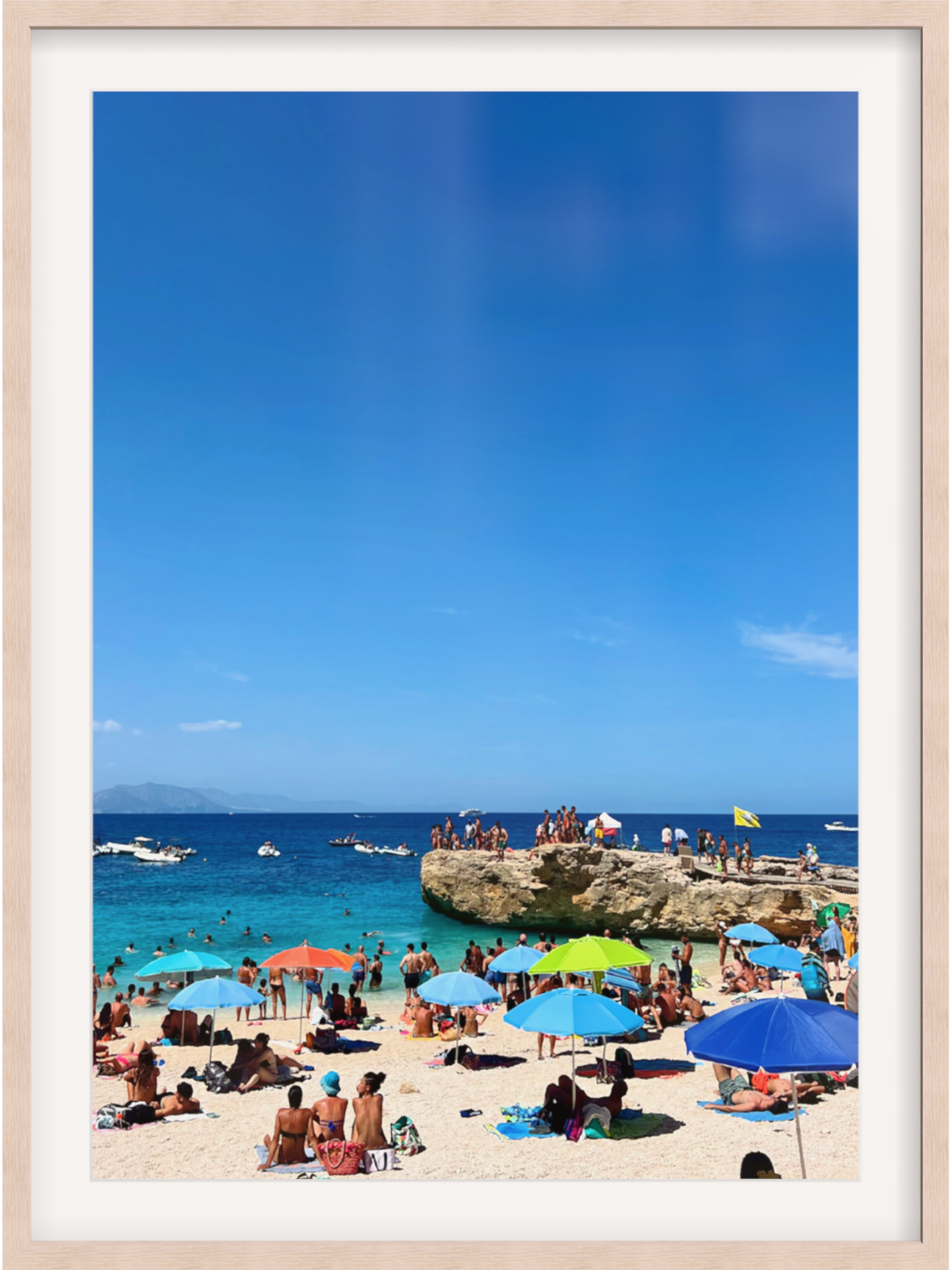 Beach scene with colorful umbrellas and people under a clear blue sky.