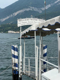 Borderless Bellagio jetty art print highlighting worn blue and white striped wooden pilings