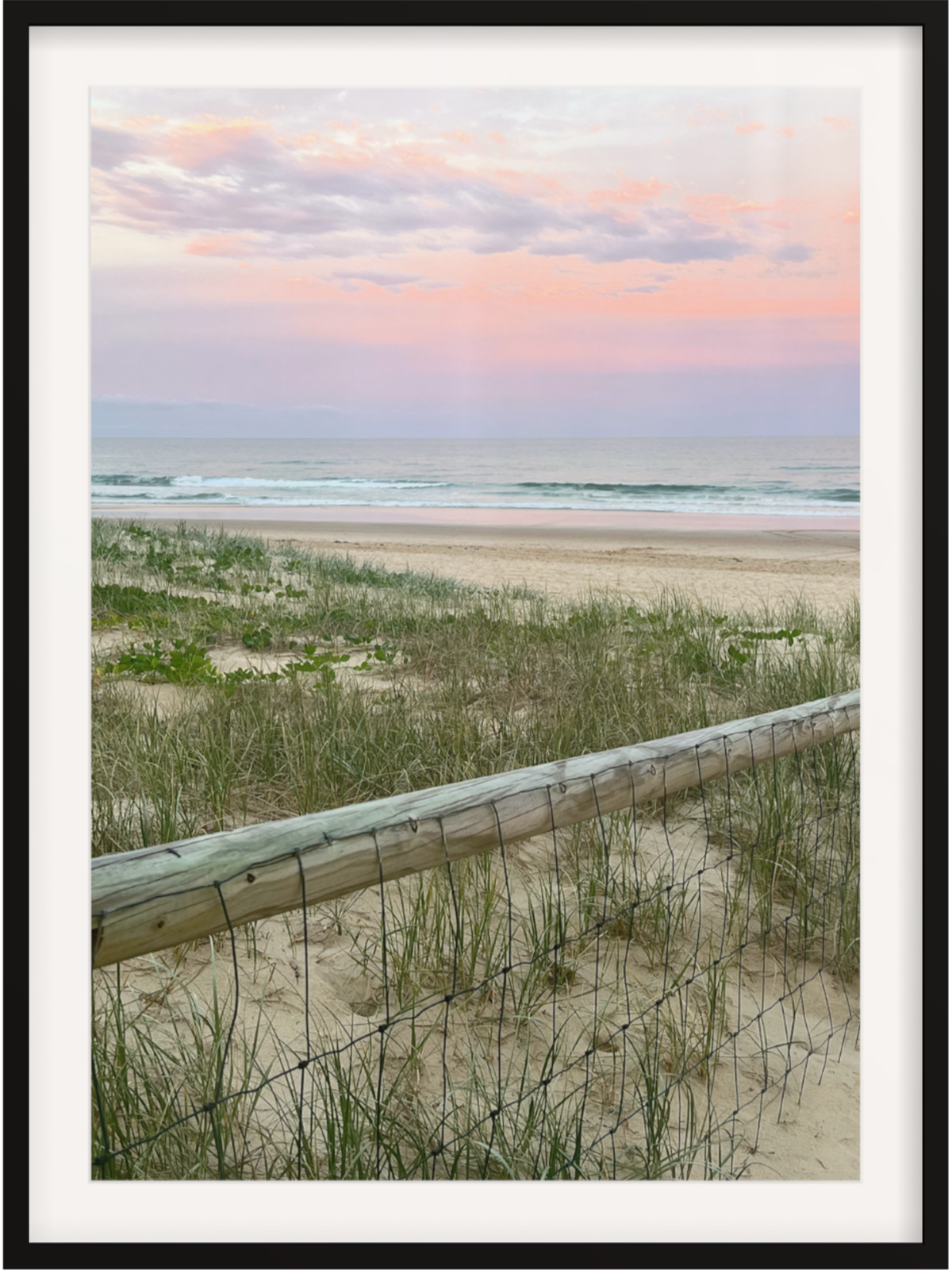 Black framed beach wall art with white mat featuring pink and lavender sky