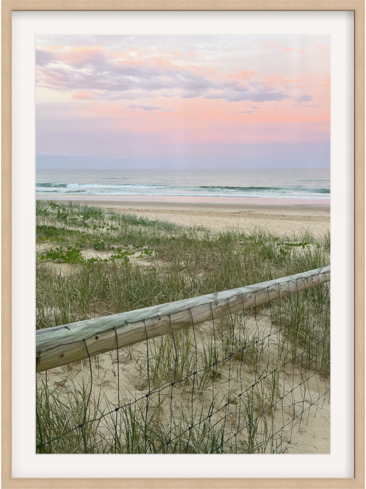 Coastal dunes and fence wall art print in light wood frame with white mat