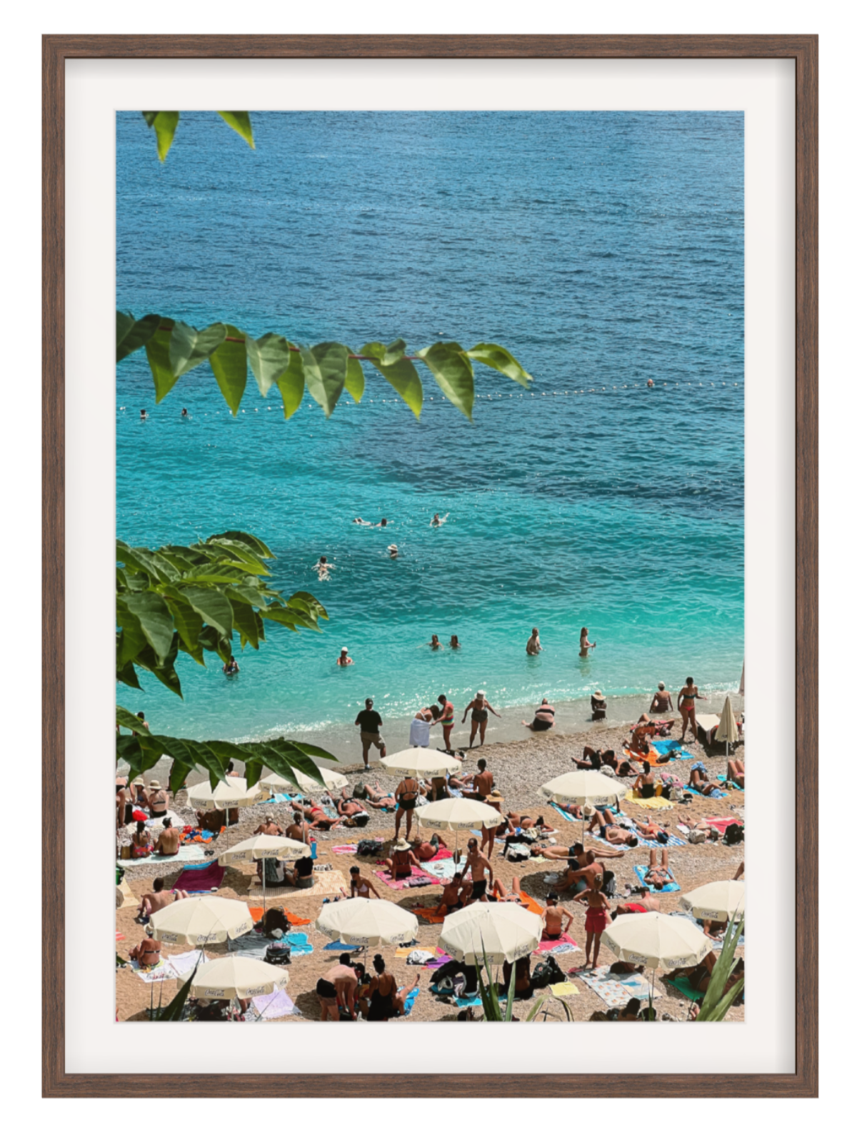 Framed photograph of a beach scene with people and umbrellas, featuring a brown frame. Chocolate frame with border