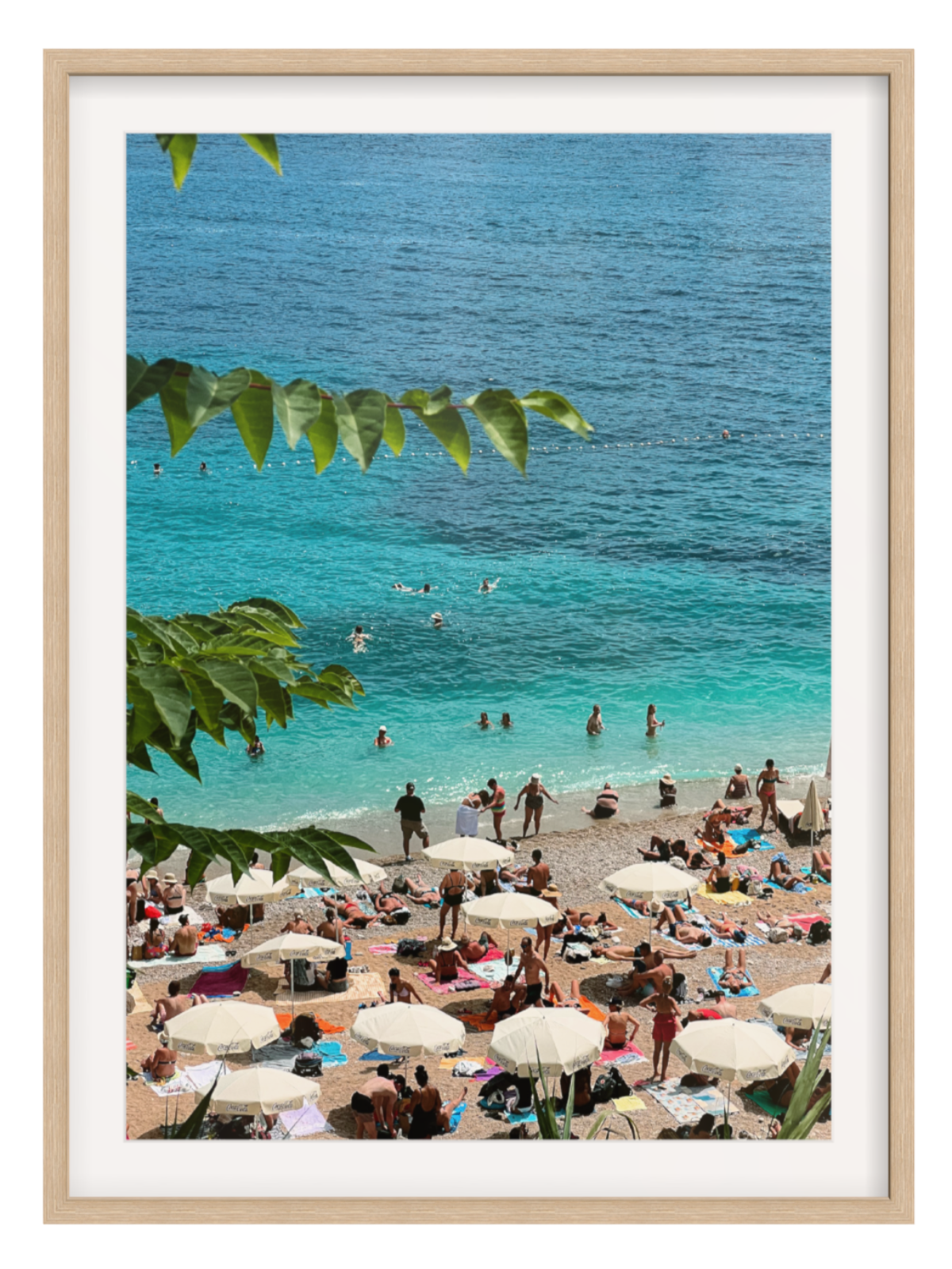 Oak Framed with border photograph of a beach scene with people, umbrellas, and clear blue water.
