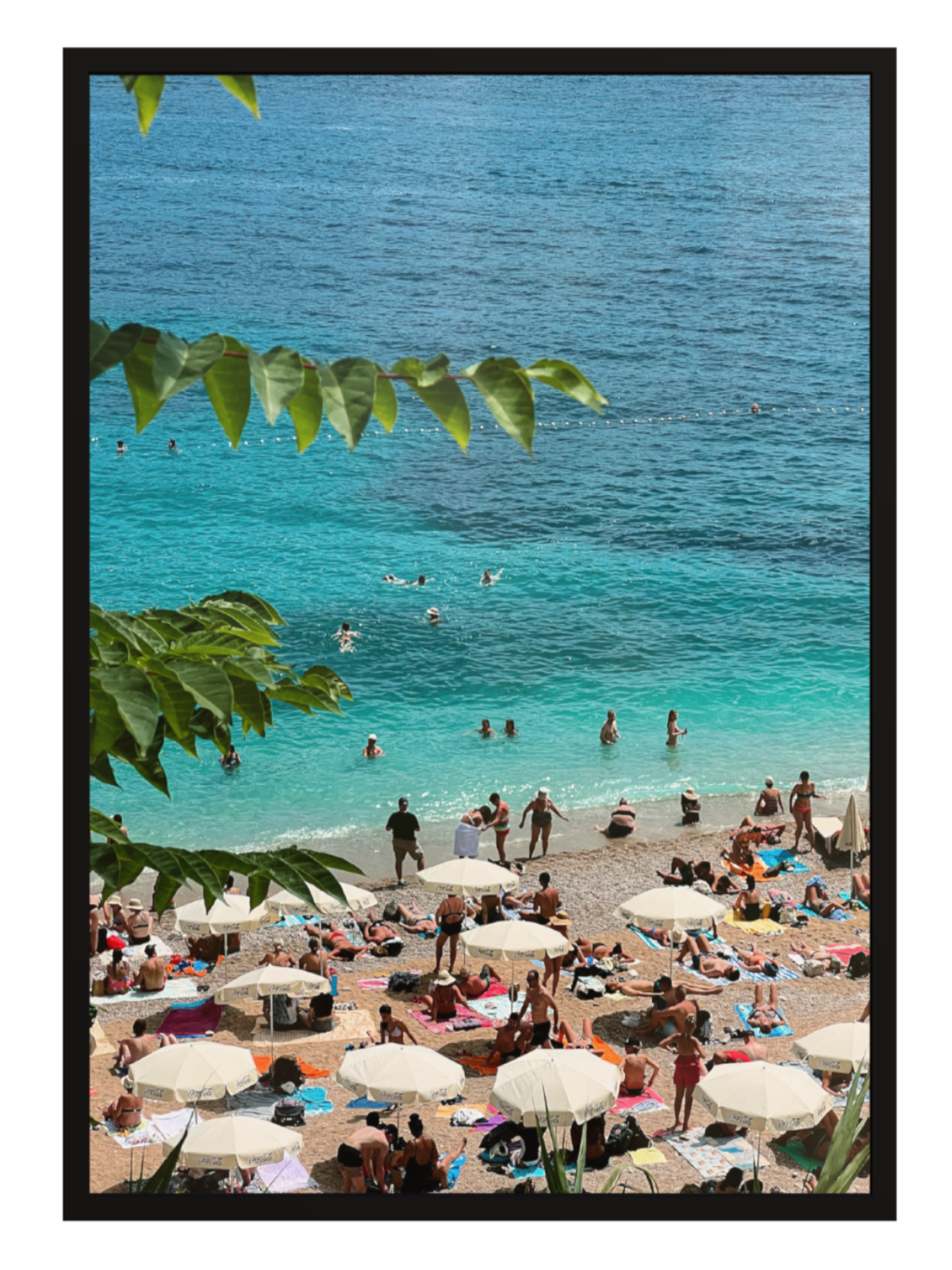 Beach scene with people, umbrellas, and clear blue water. Banje Beach leaf black frame