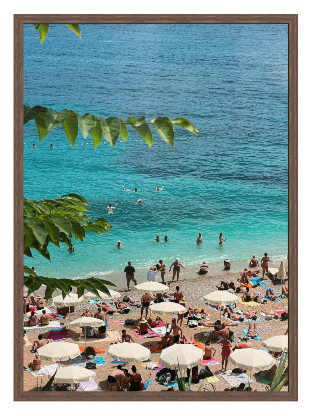 Beach scene with people and umbrellas, framed with green leaves. Banje Beach leaf chocolate frame