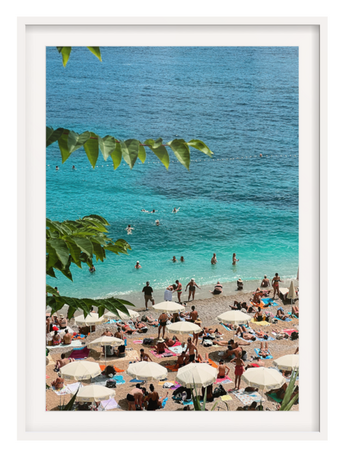 Beach scene with people, umbrellas, and clear blue water. white frame with border