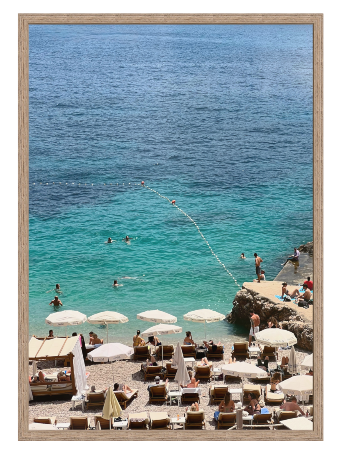 Beach scene with people, umbrellas, and chairs near a body of water. hazel frame