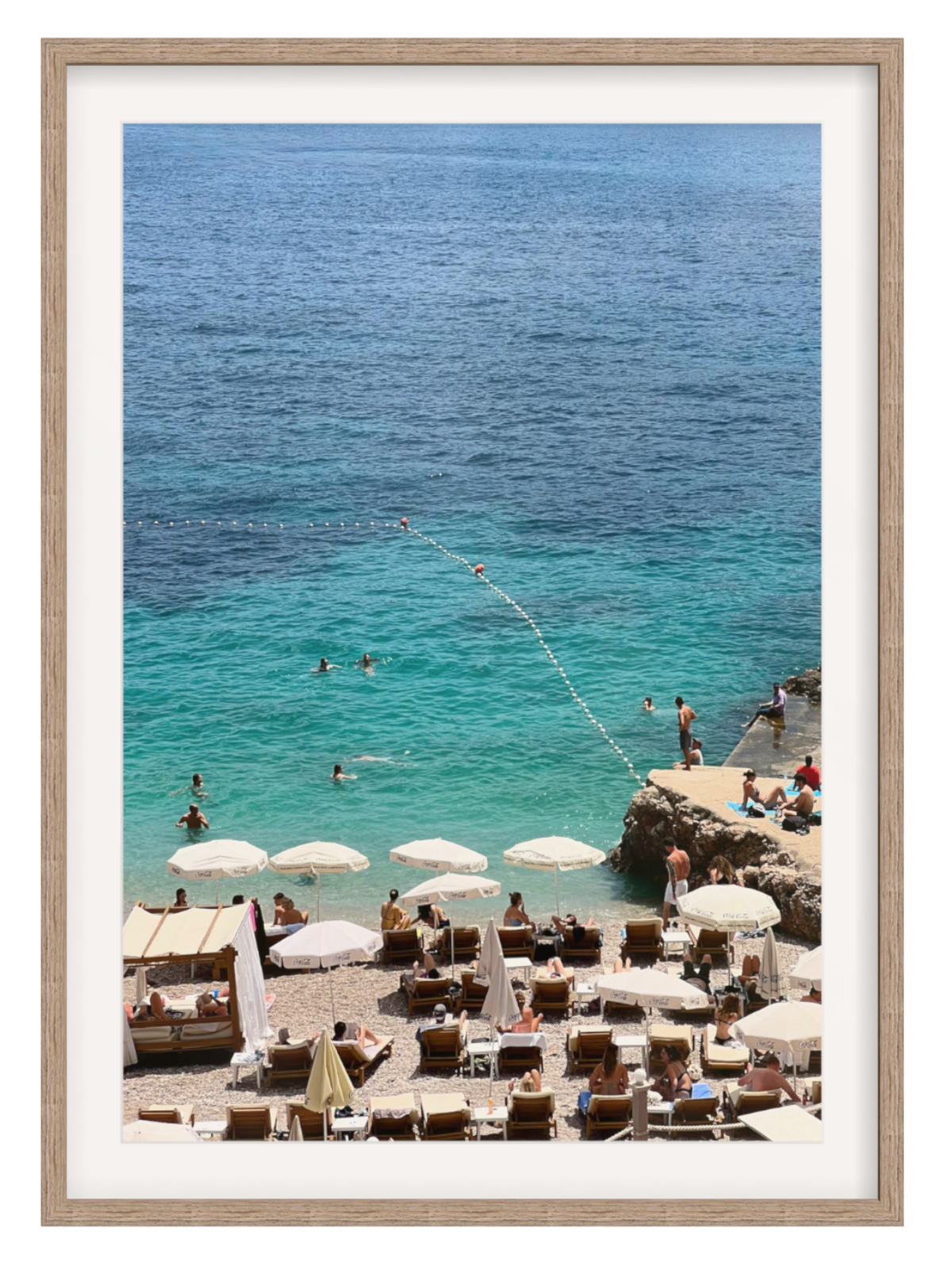 Beach scene with people, umbrellas, and chairs near a body of water. 
