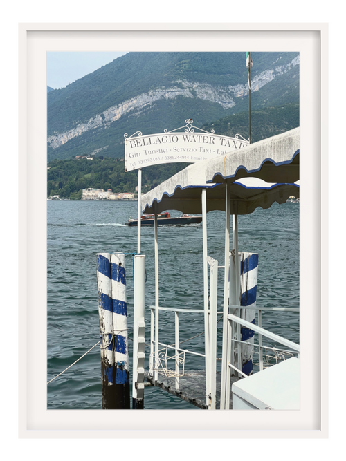 Lake Como waterside scene art print with dark water taxi and green mountains in white border frame