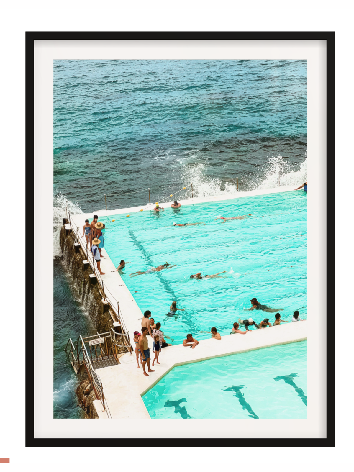 People enjoying a pool by the ocean with a black frame.