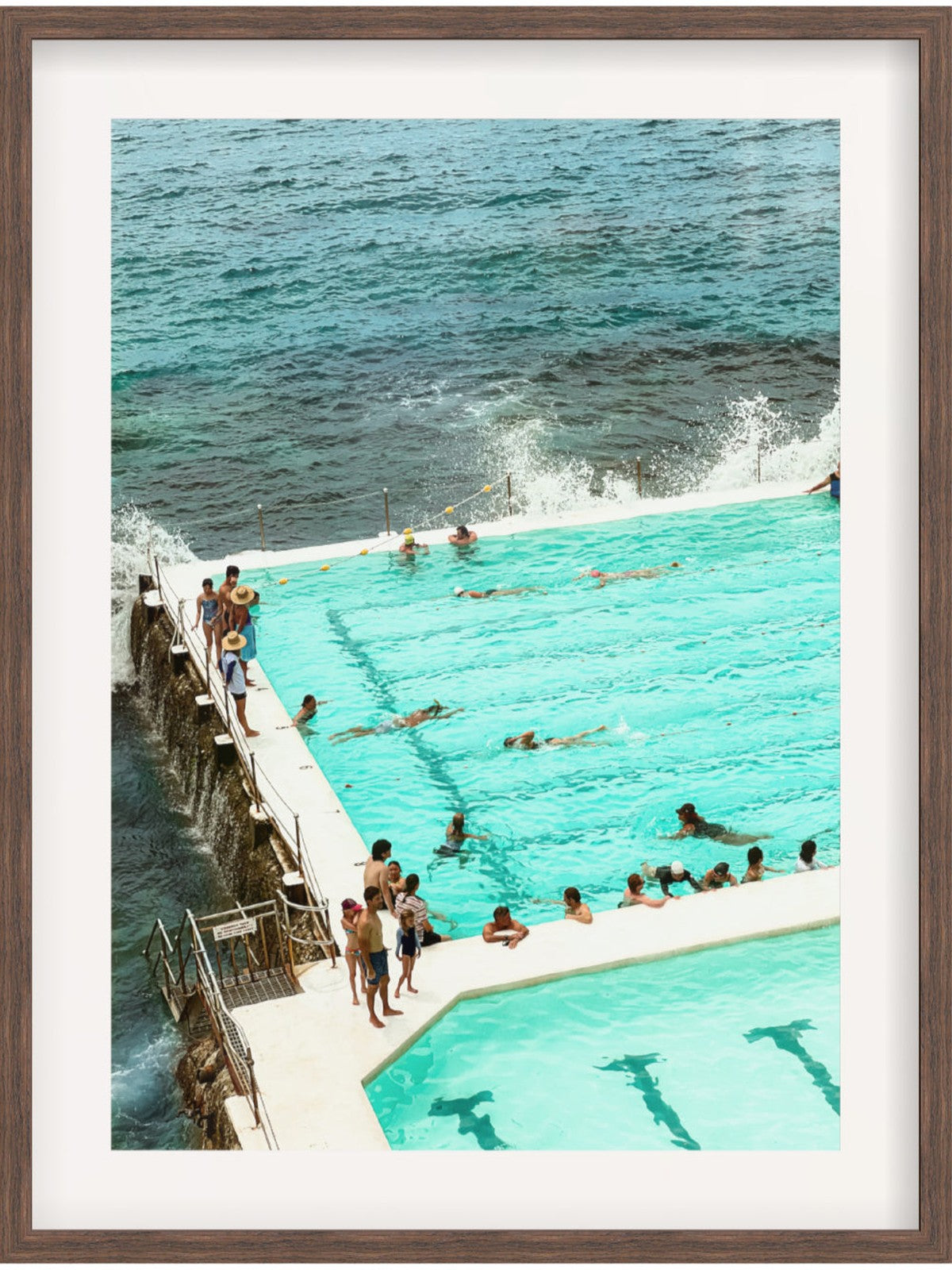 People swimming in a pool with ocean view, framed picture
