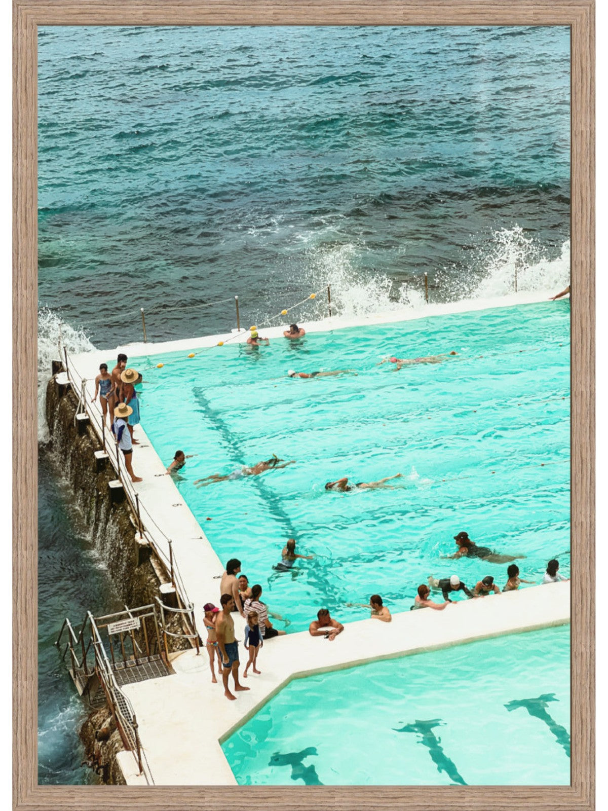People swimming in a pool with ocean view and wooden frame