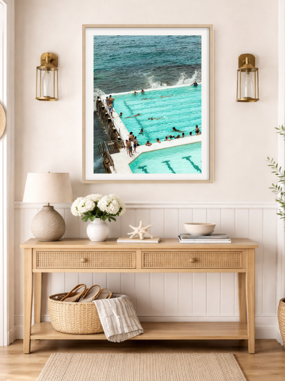 Framed artwork of a pool scene above a wooden console table with decorative items.