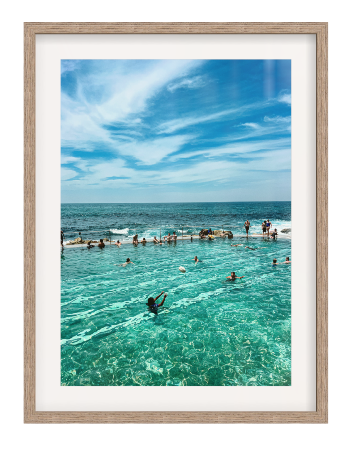 Framed photograph of a pool with people swimming against a blue sky.