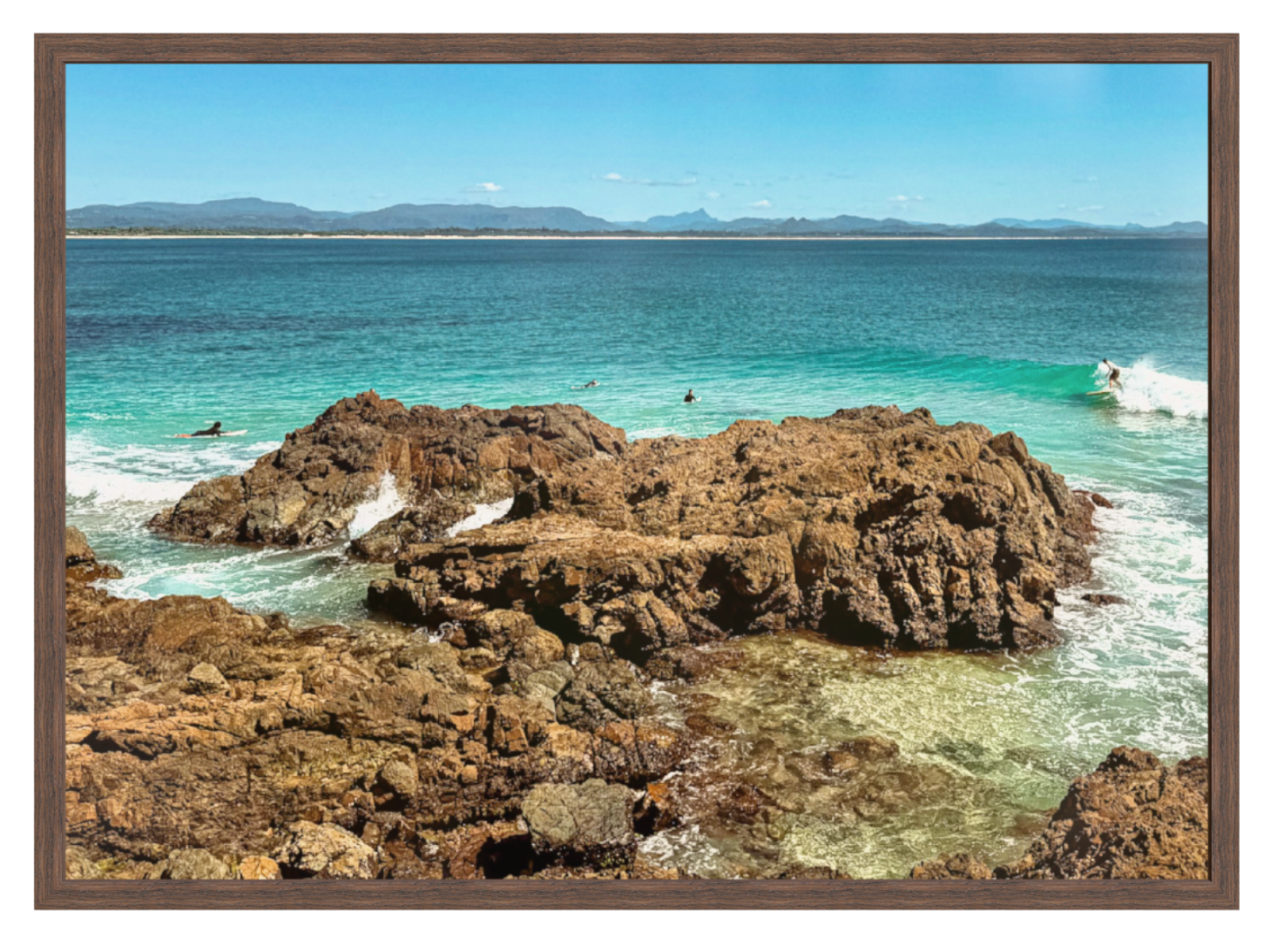 Rocks by the ocean with a clear blue sky