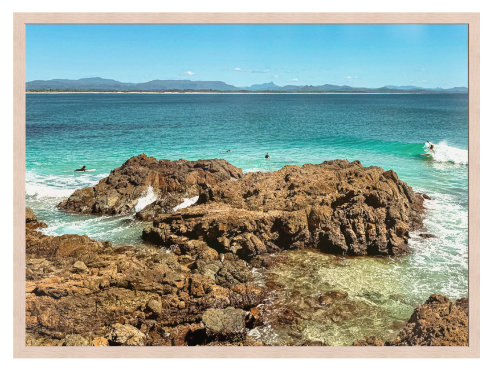 Rocks in a body of water with a clear blue sky