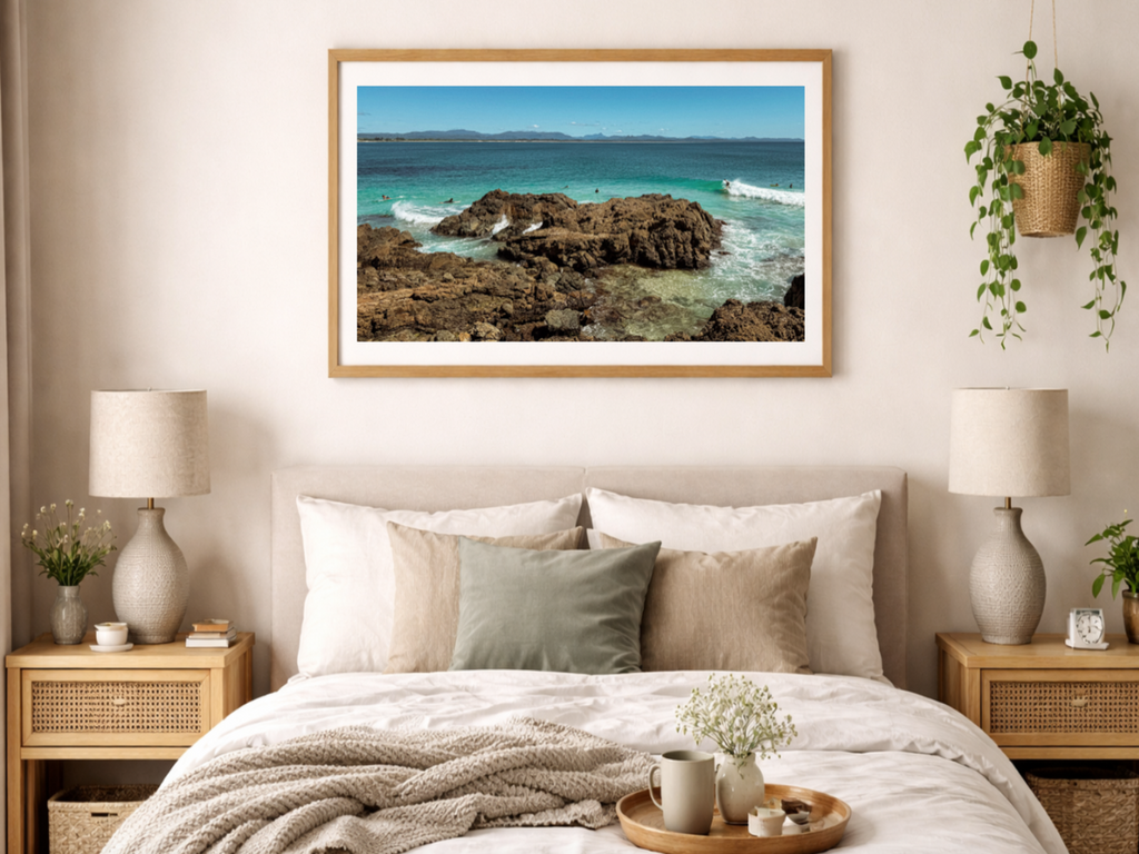 Bedroom with a large framed picture of a coastal scene on the wall.