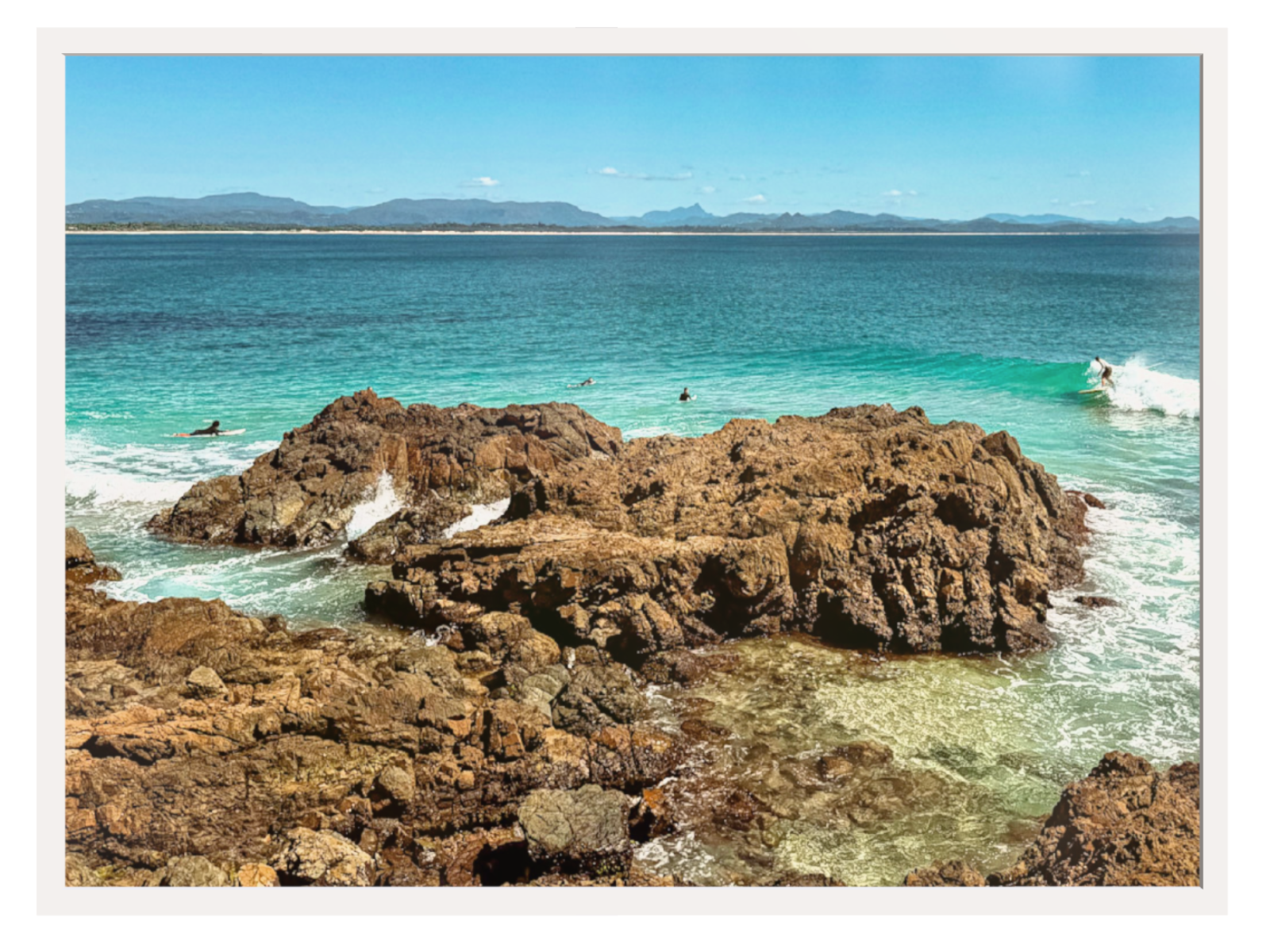 Rocks in a body of water with a clear sky