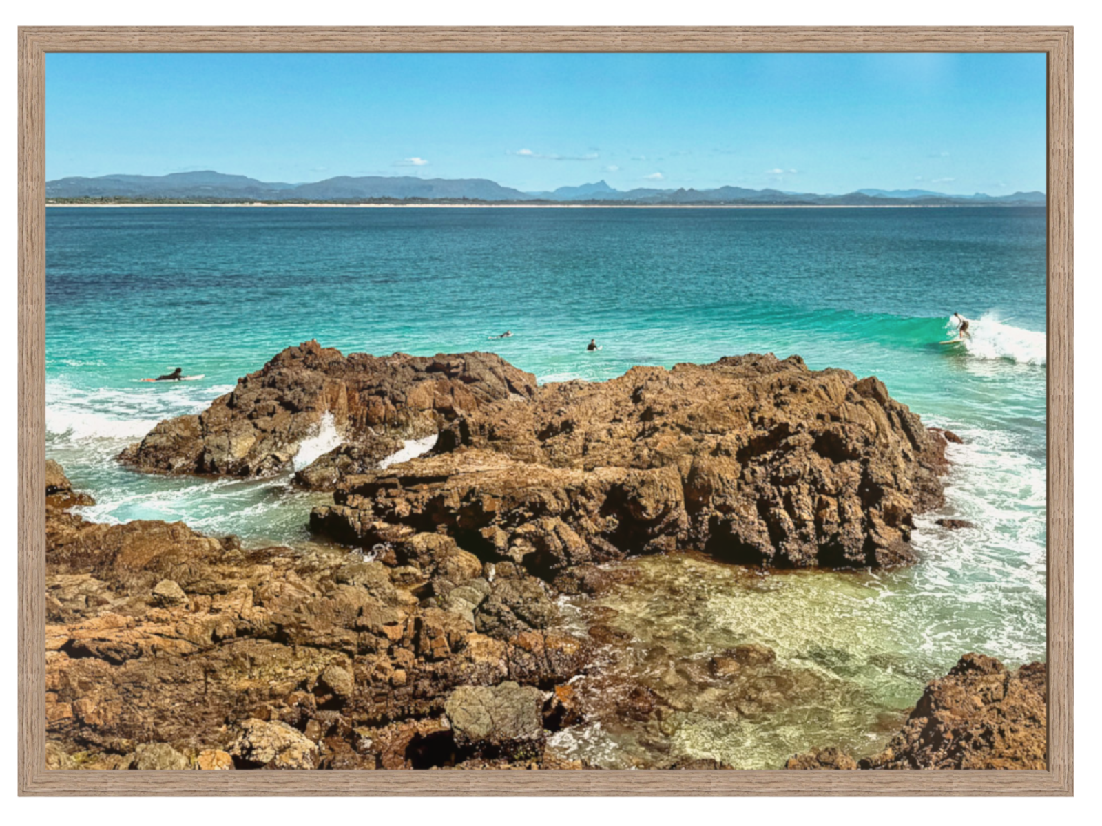 Rocks by the ocean with a clear blue sky