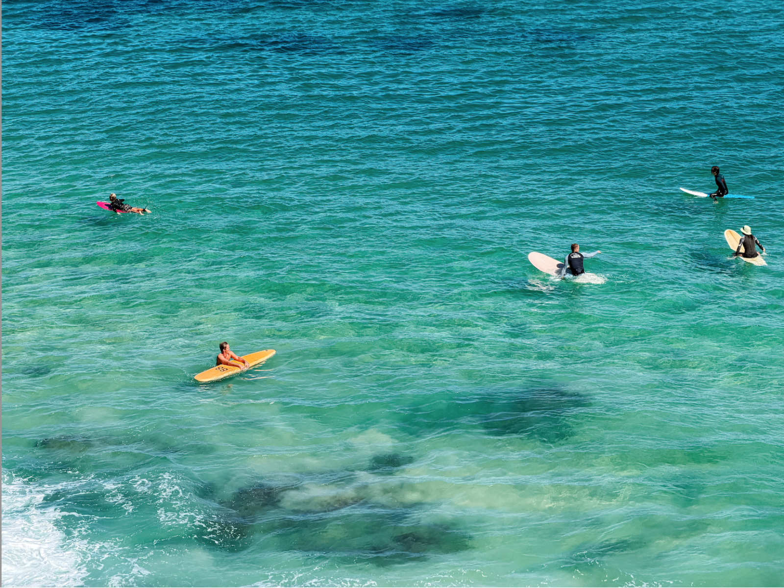 People on surfboards in clear blue water