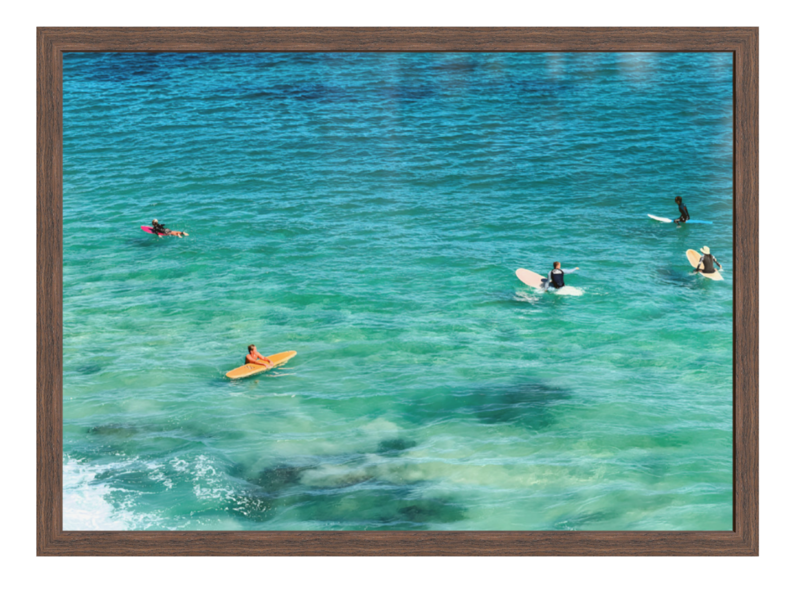 People on surfboards in clear blue water with a wooden frame