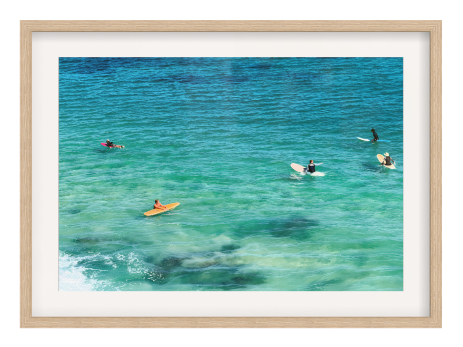 People on surfboards in clear blue water with a wooden frame.