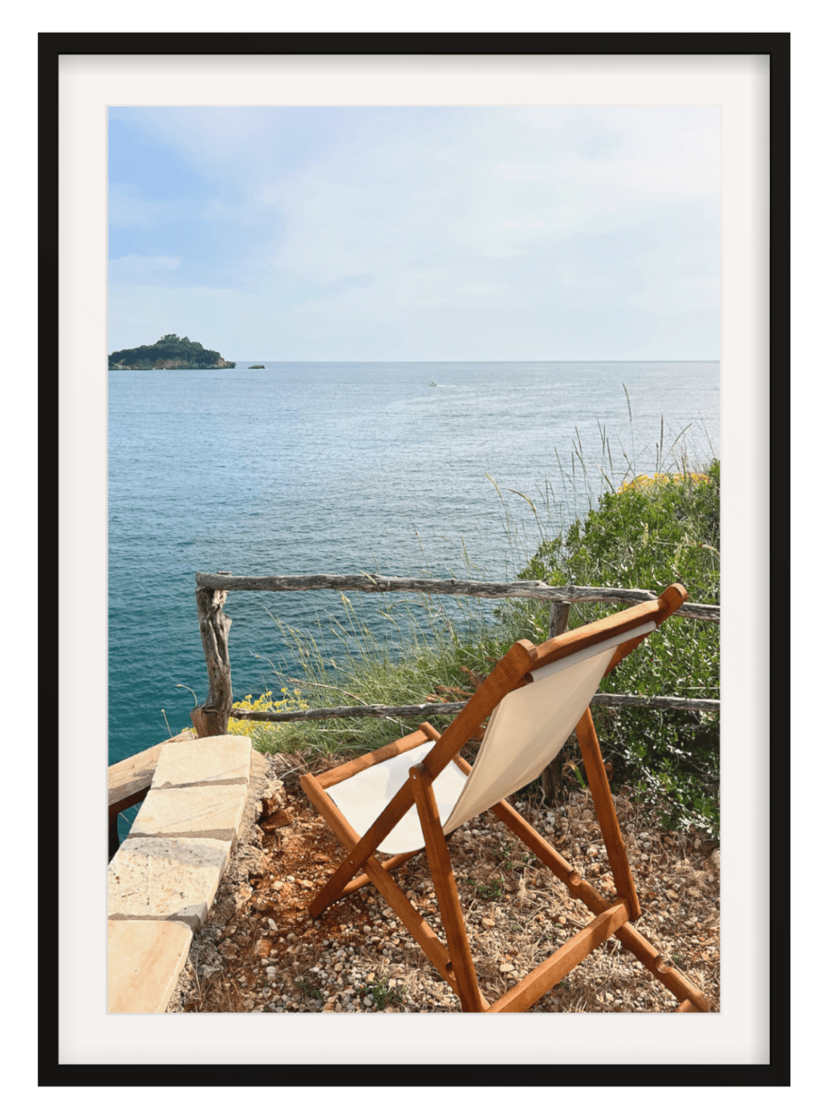 Wooden chair with white cushion overlooking a scenic ocean view with an island.