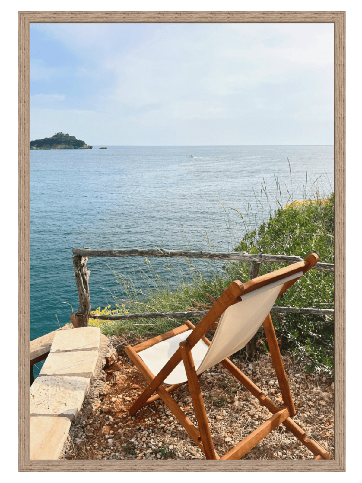 Wooden chair with white cushion overlooking a scenic ocean view.