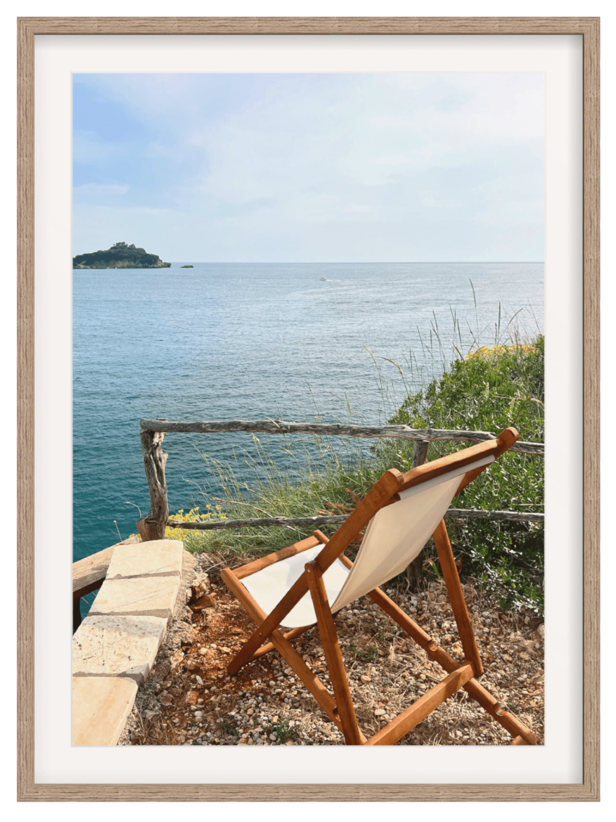 Wooden chair with white cushion overlooking a body of water and a small island.