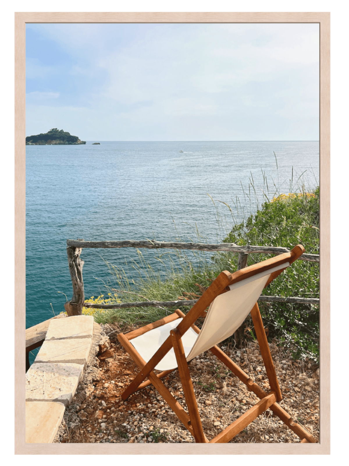 Wooden chair with white cushion facing the ocean from a scenic viewpoint.