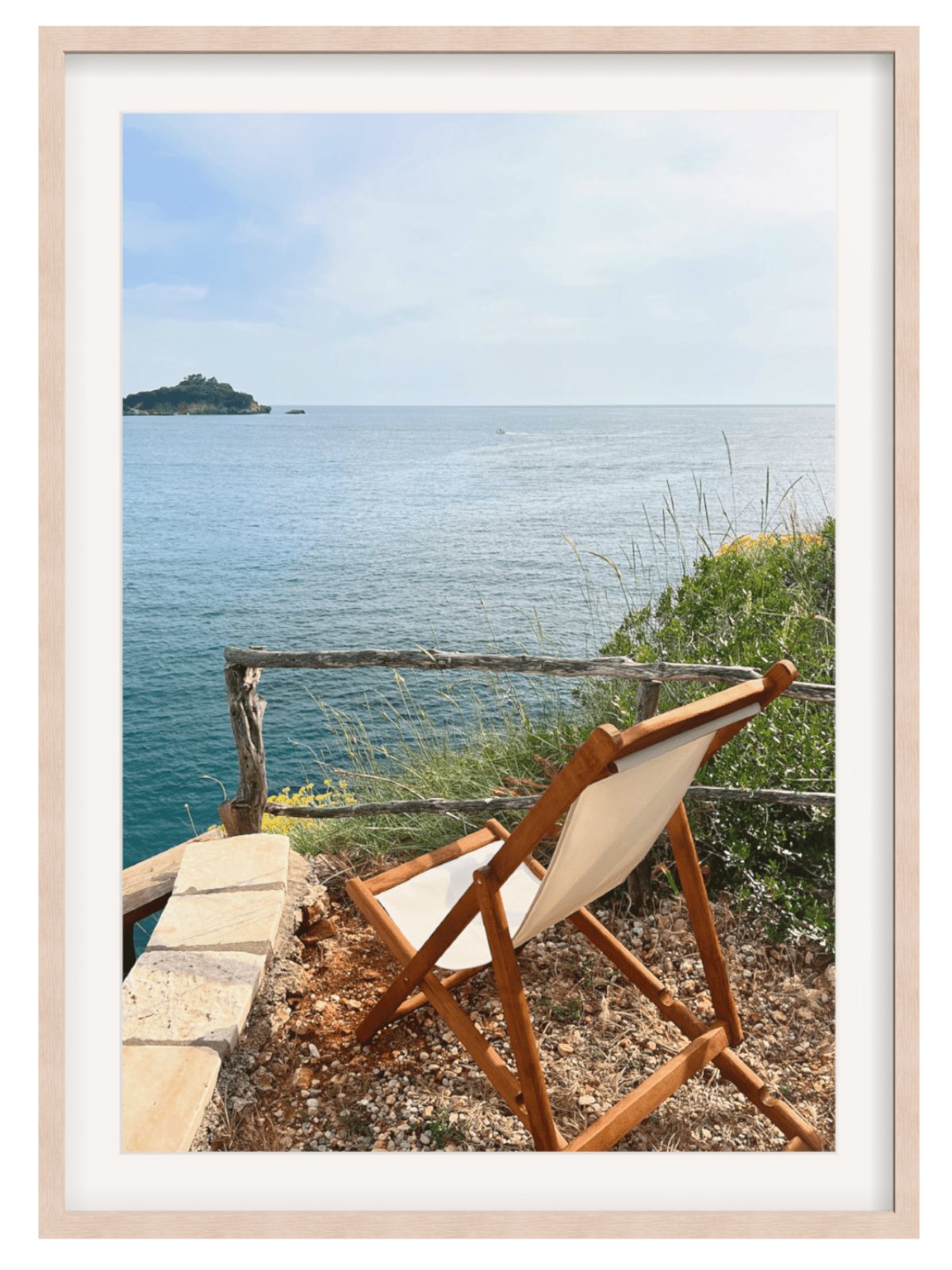 Wooden chair with white cushion overlooking a scenic ocean view.