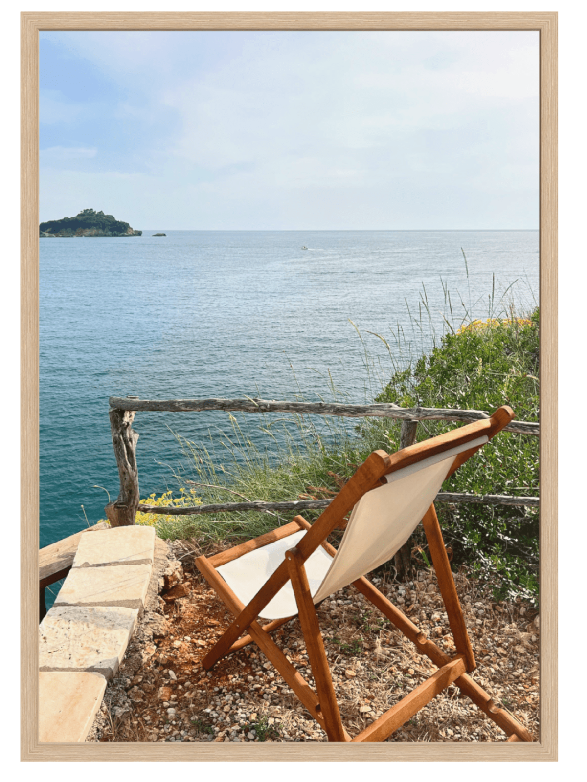 Wooden deck chair with white cushion overlooking a scenic ocean view.