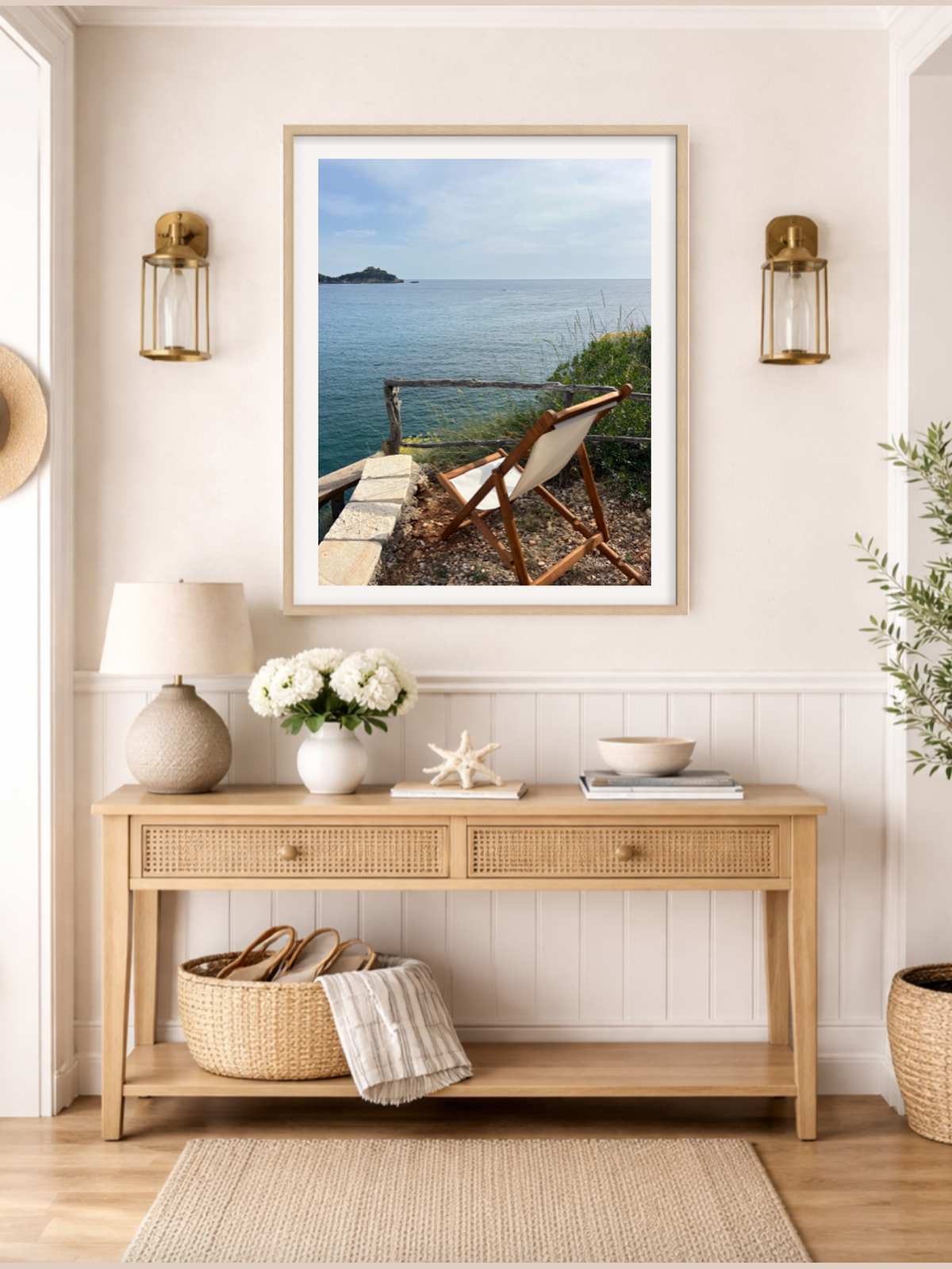 Nautical-themed room with a framed picture of a beach scene, lamp, and decorative items on a wooden console table.