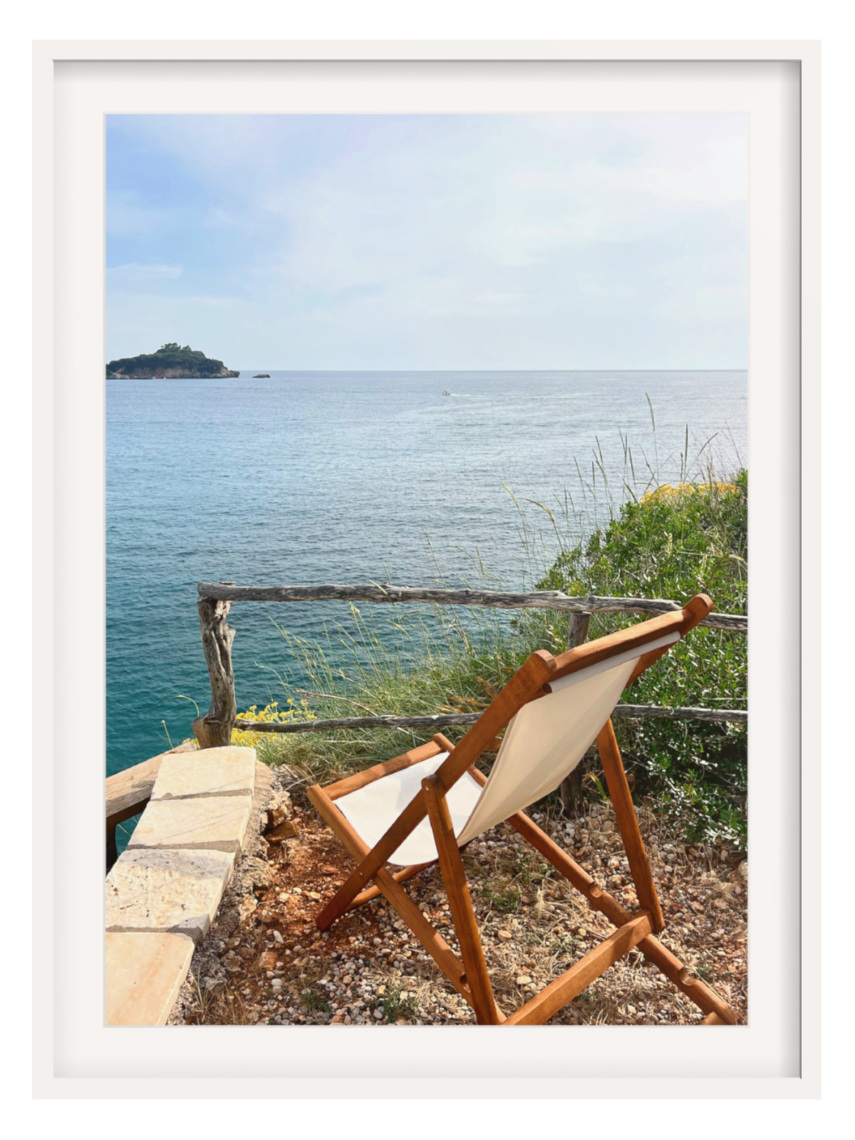 Wooden chair with white cushion overlooking a scenic ocean view.