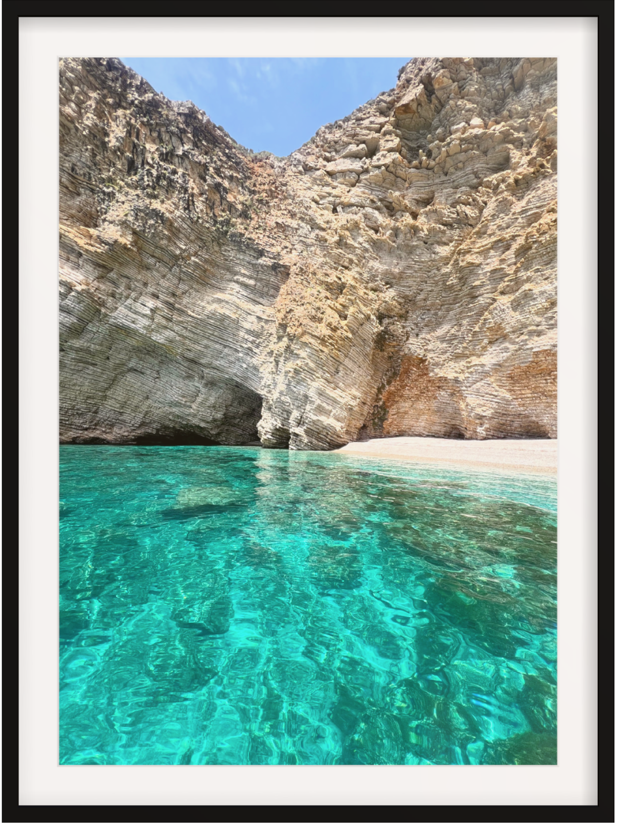 Clear turquoise water and rocky cliffs in a natural cove.
