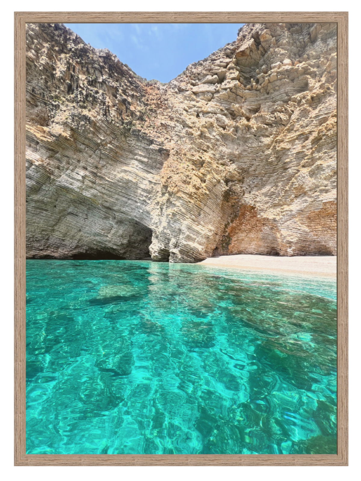 Clear turquoise water in a natural rock formation with a sandy beach.