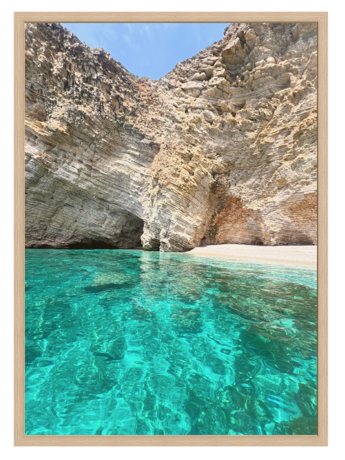 Clear turquoise water with rocky cliffs in the background