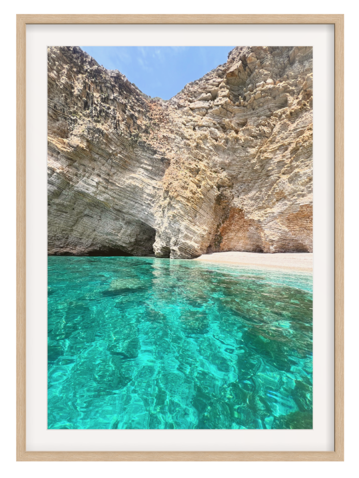 Framed photograph of a rocky beach with clear turquoise water