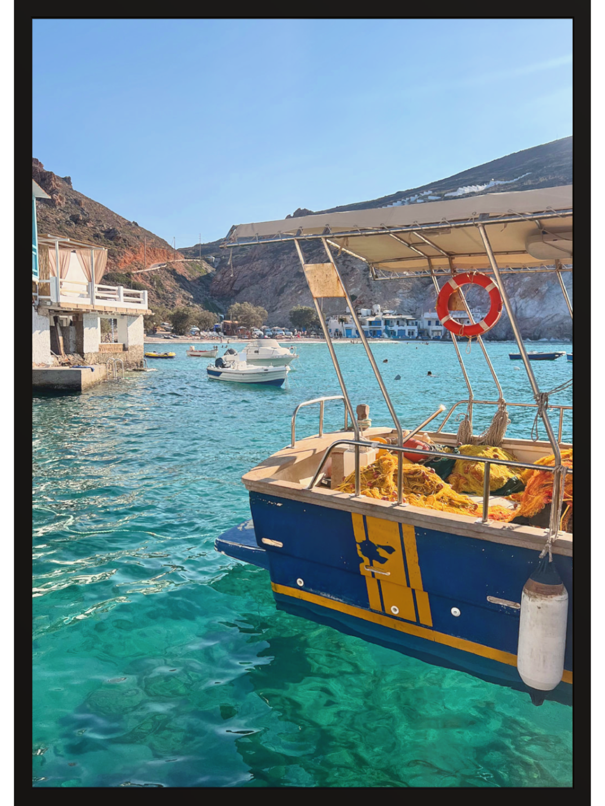 Boat with a canopy on a clear day near a coastal area with mountains.