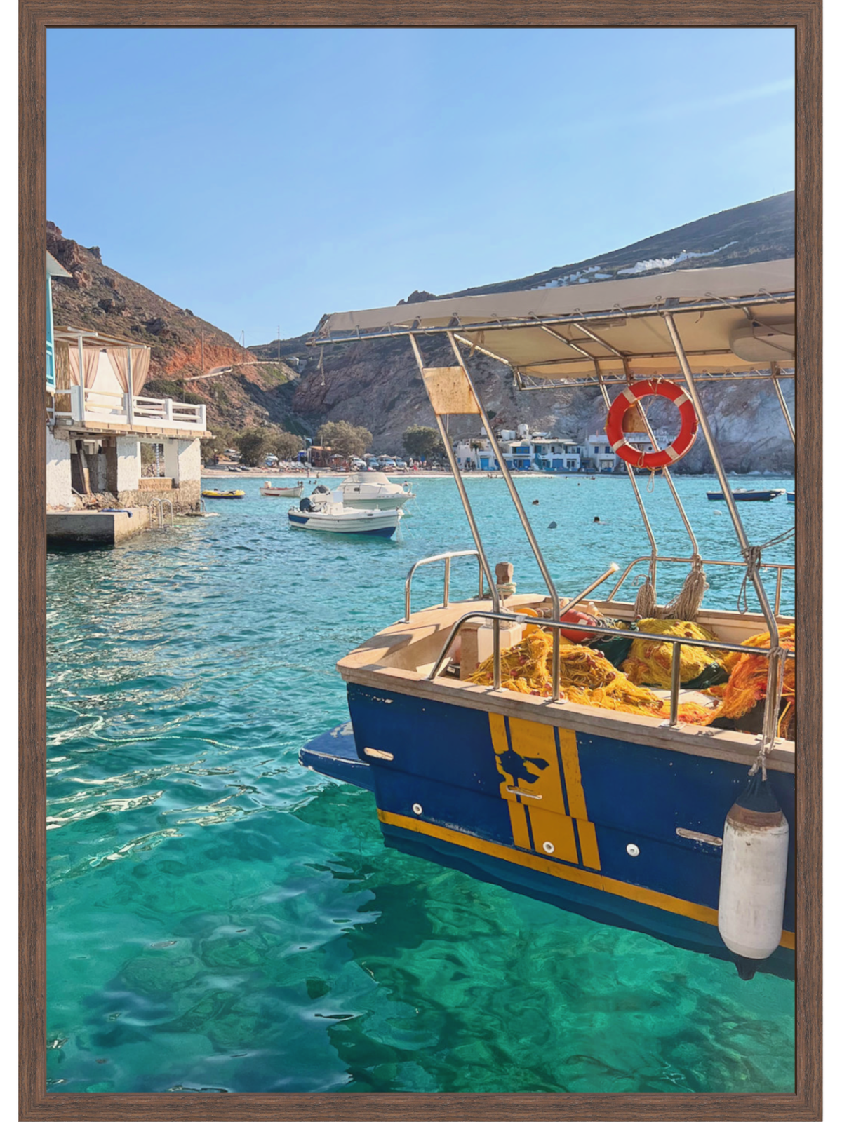 Boat in a harbor with clear blue water and mountains in the background