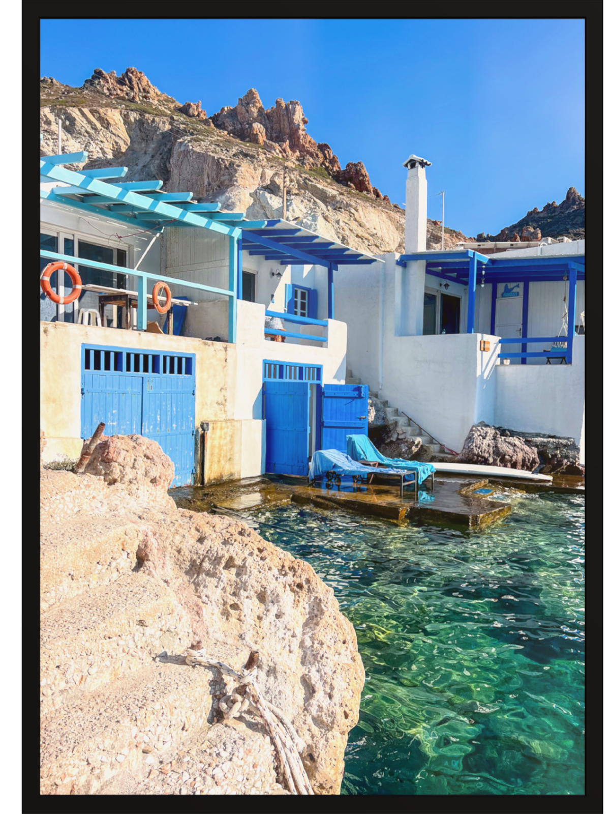 Greek village wall art in black frame depicting submerged rocks and stone dock