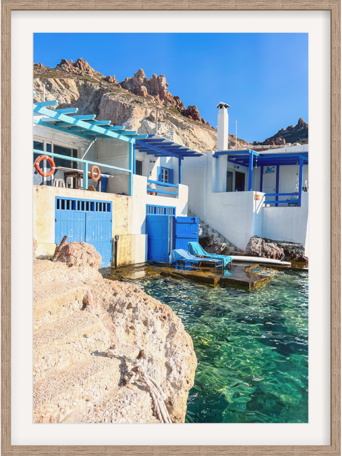 Firopotamos Milos print in light wood frame with arid cliffs and blue pergolas