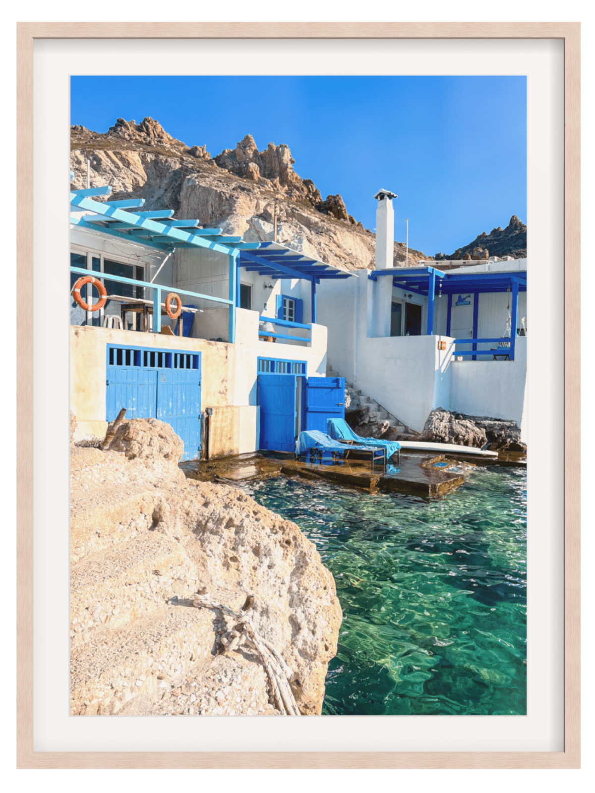 Firopotamos Milos coastal wall art in light wood frame with blue doors and turquoise water