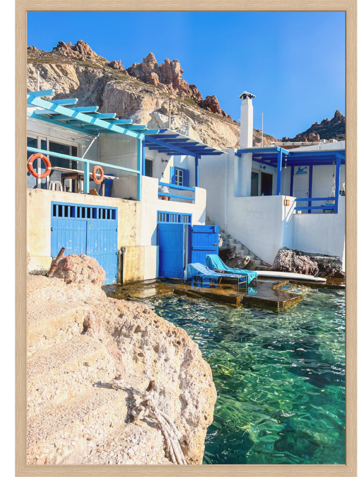 Greek coastal wall art in light wood frame highlighting sunlit turquoise sea