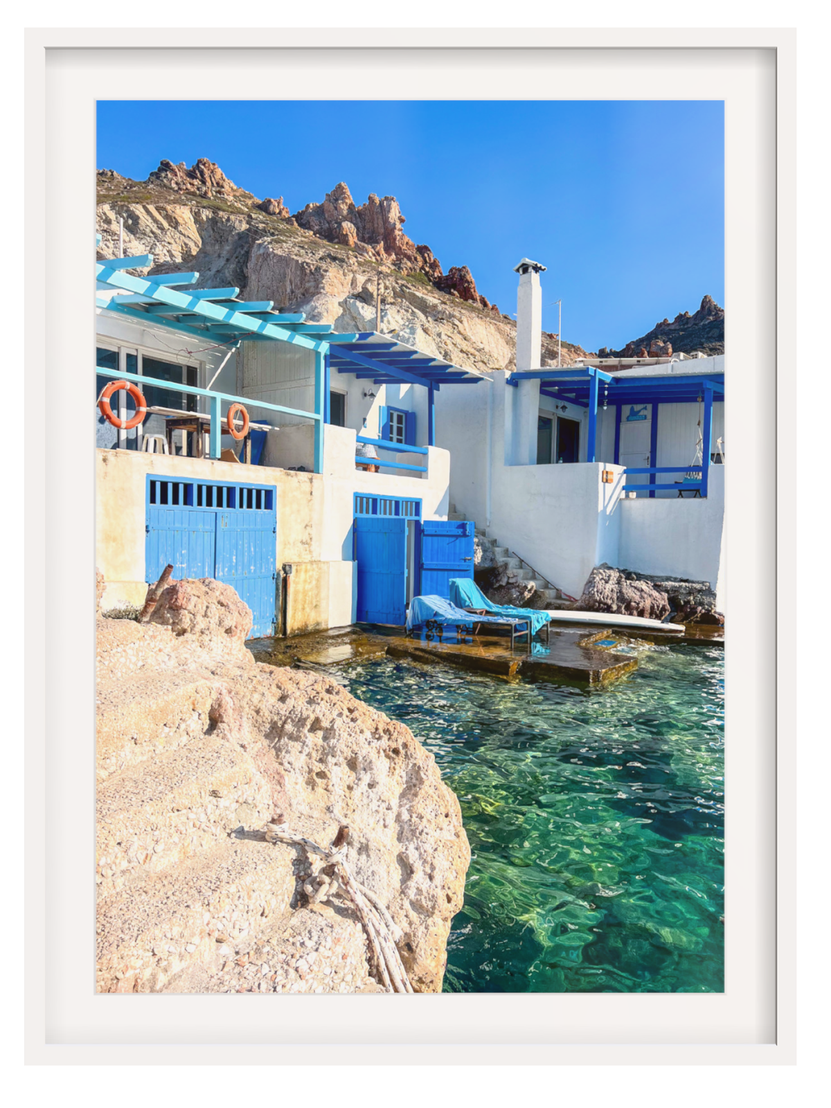 Firopotamos seaside wall art with white border showing blue shutters and life rings