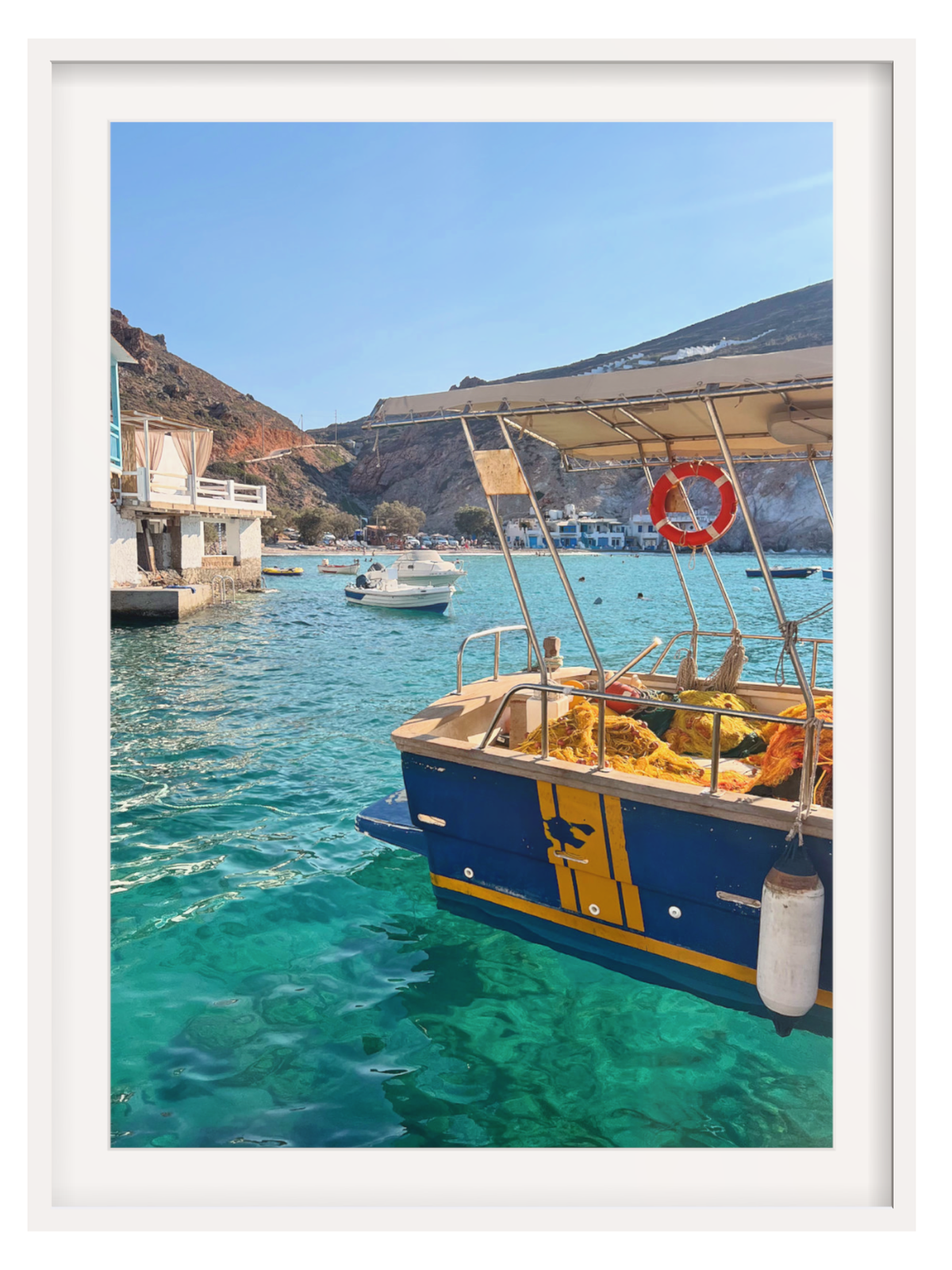 Boat docked in a harbor with clear blue water and rocky cliffs in the background.