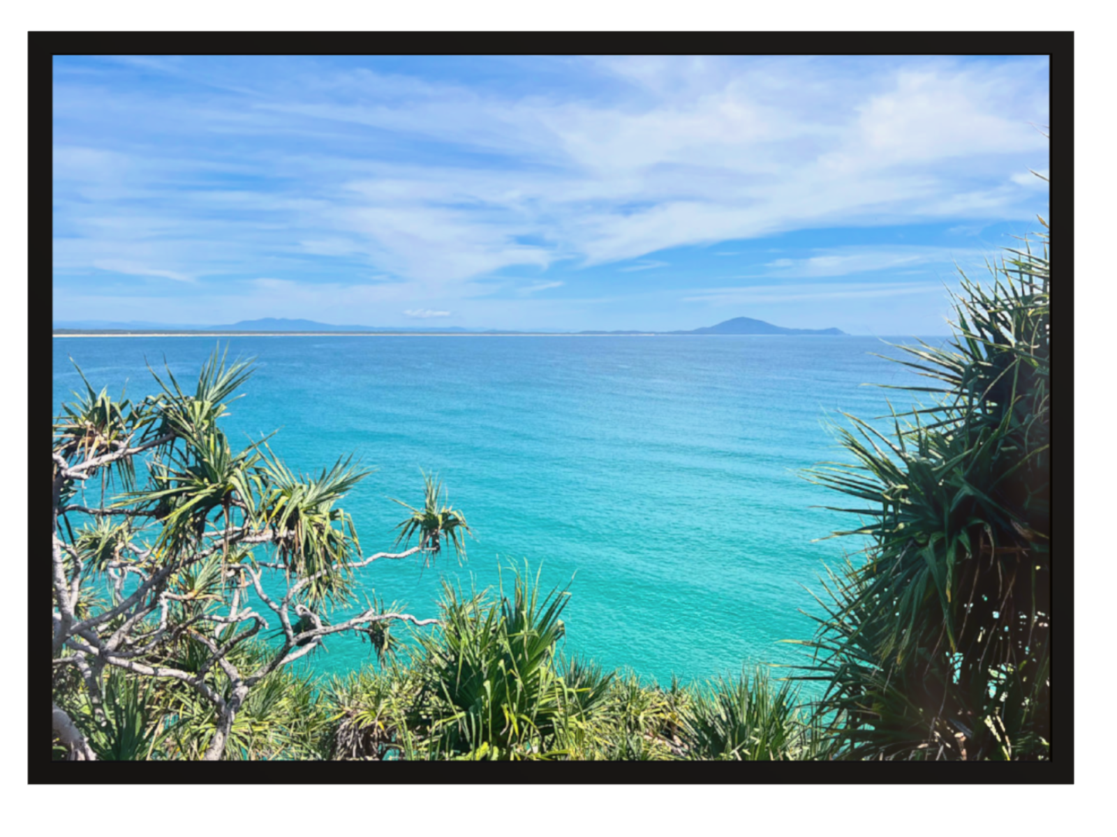 Scenic view of a tropical beach with clear blue water and greenery.