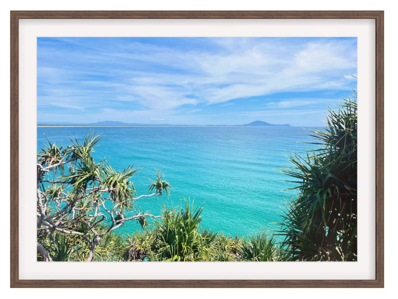 Framed photograph of a tropical beach with clear blue water and sky.