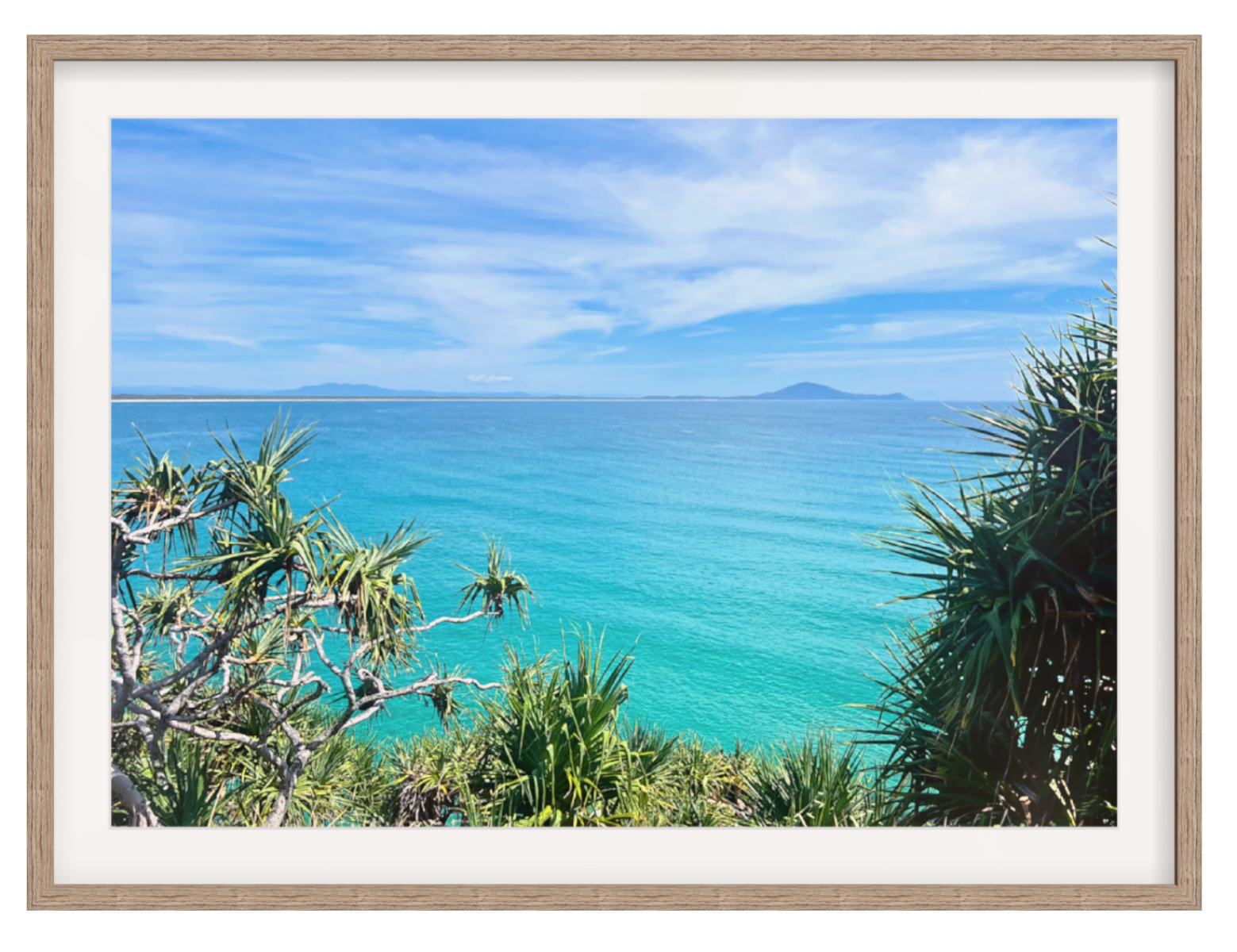 Framed photograph of a tropical beach with clear blue water and palm trees.