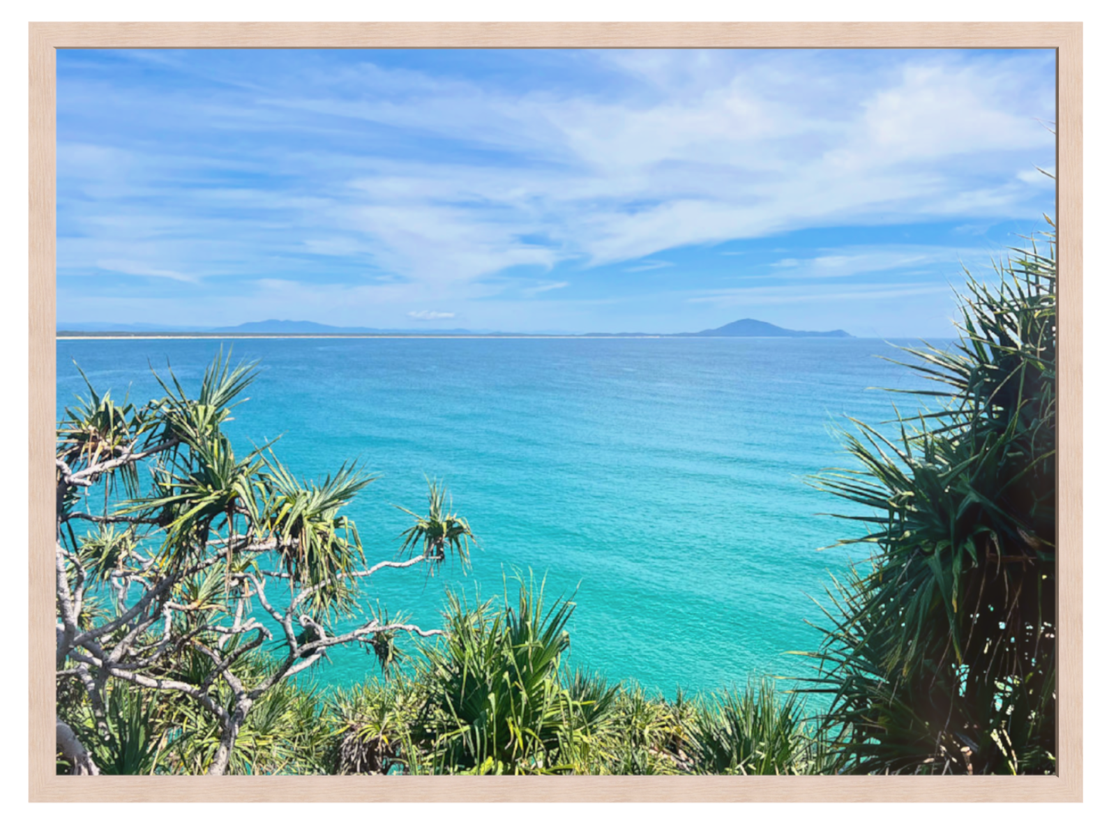 Framed artwork of a tropical beach scene with turquoise water and clear sky.
