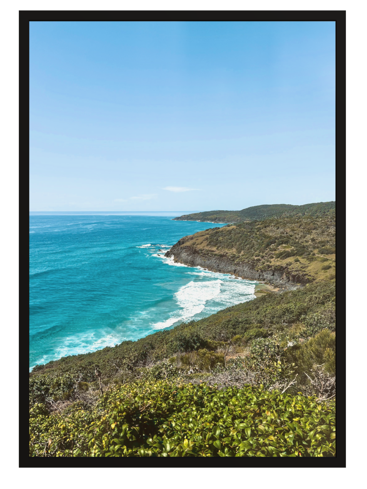 Hat Head Australia coastal print in solid black frame without mat showing blue ocean and vegetated cliffs
